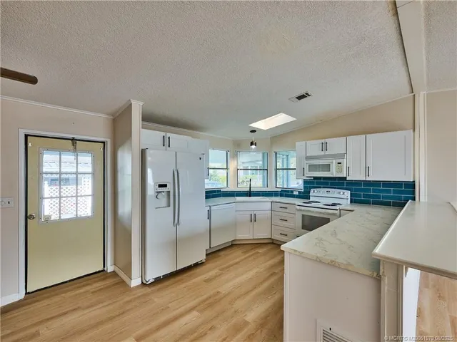 a kitchen with a refrigerator a sink and cabinets