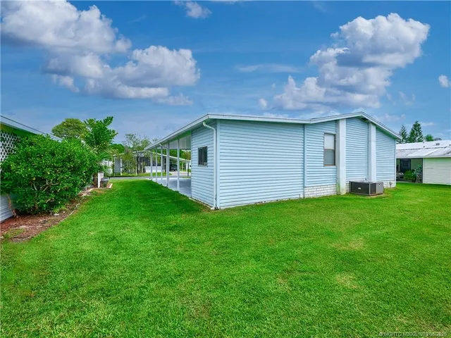 a view of a backyard with plants and a large tree