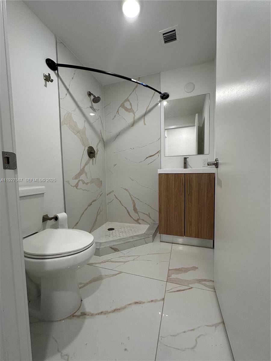 14573 Southwest 261st Terrace, Unit 14573 Homestead, FL 33032 - Photo 12 of 35 a bathroom with a sink toilet and shower