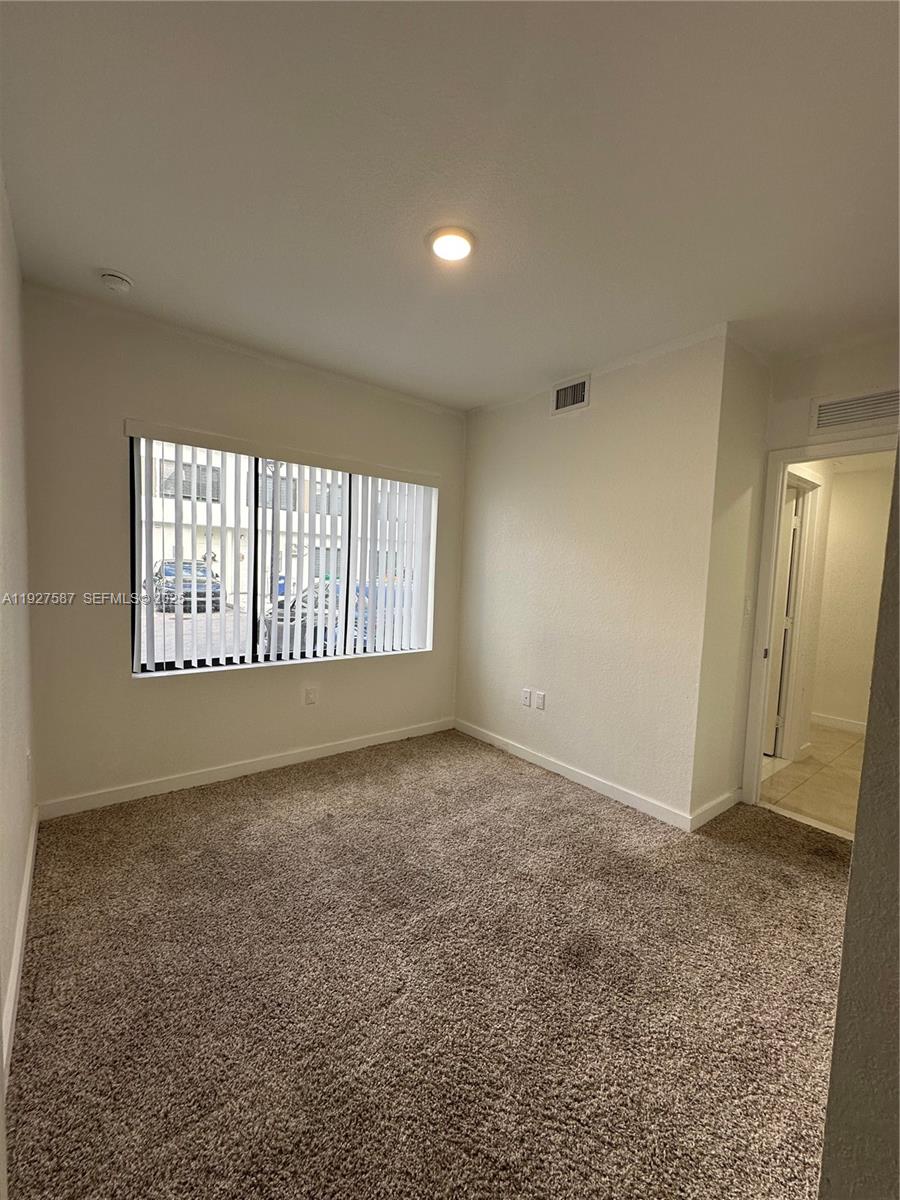 14573 Southwest 261st Terrace, Unit 14573 Homestead, FL 33032 - Photo 14 of 35 an empty room with windows