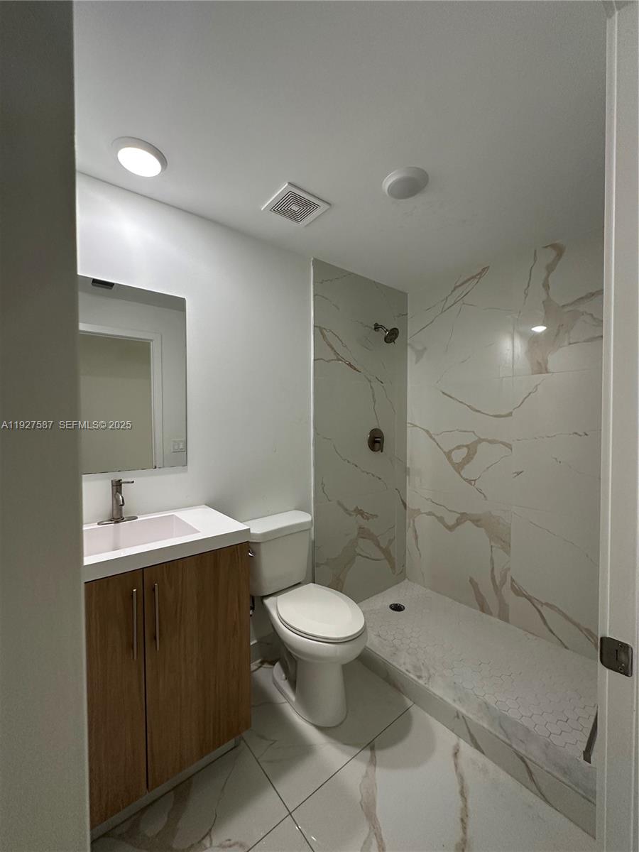 14573 Southwest 261st Terrace, Unit 14573 Homestead, FL 33032 - Photo 17 of 35 a bathroom with a sink toilet vanity and shower