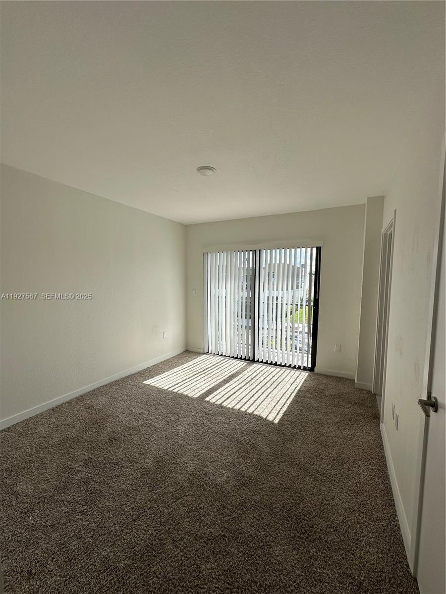 14573 Southwest 261st Terrace, Unit 14573 Homestead, FL 33032 - Photo 19 of 35 a view of an empty room with a window