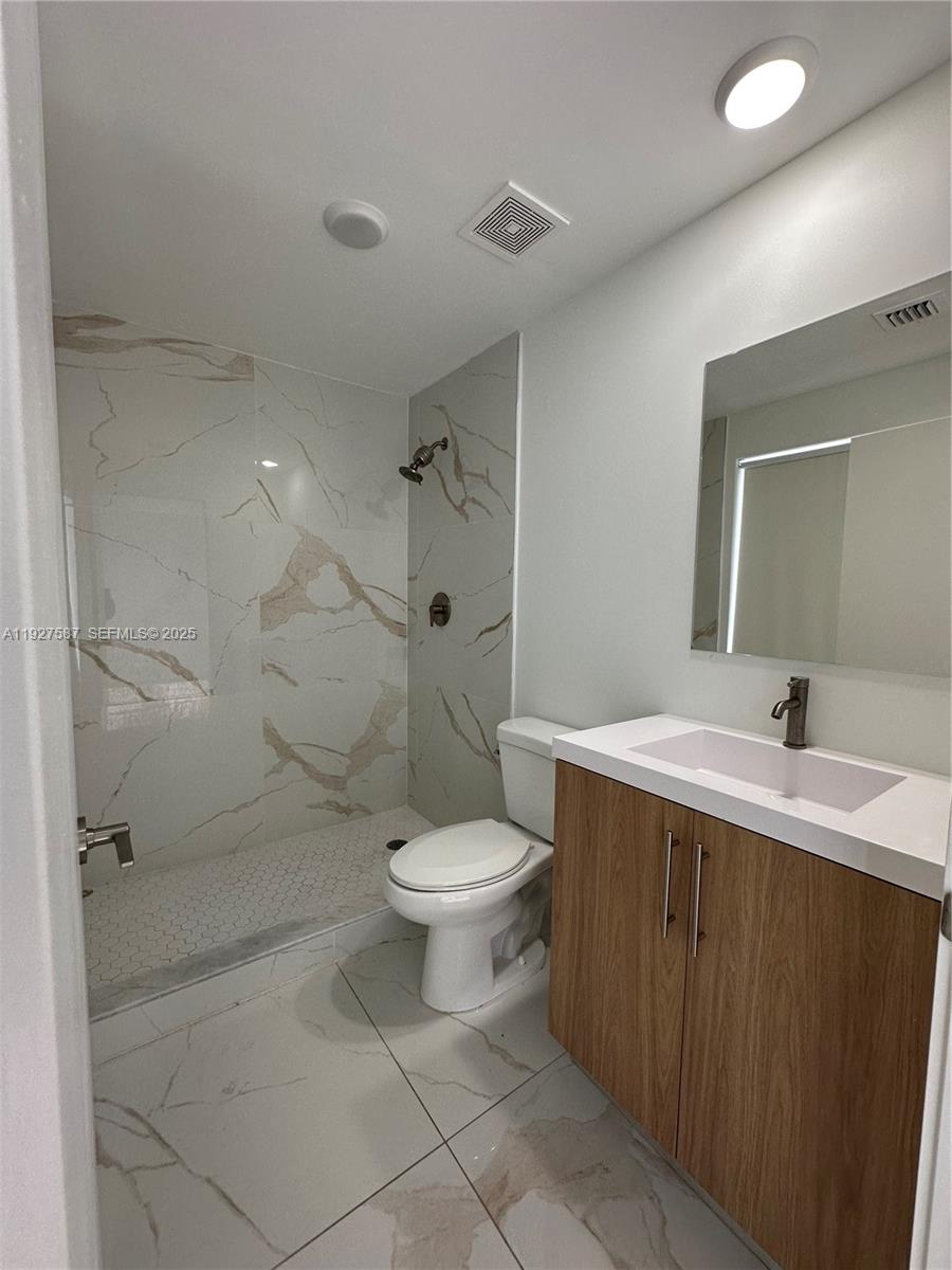 14573 Southwest 261st Terrace, Unit 14573 Homestead, FL 33032 - Photo 22 of 35 a bathroom with a sink toilet and shower