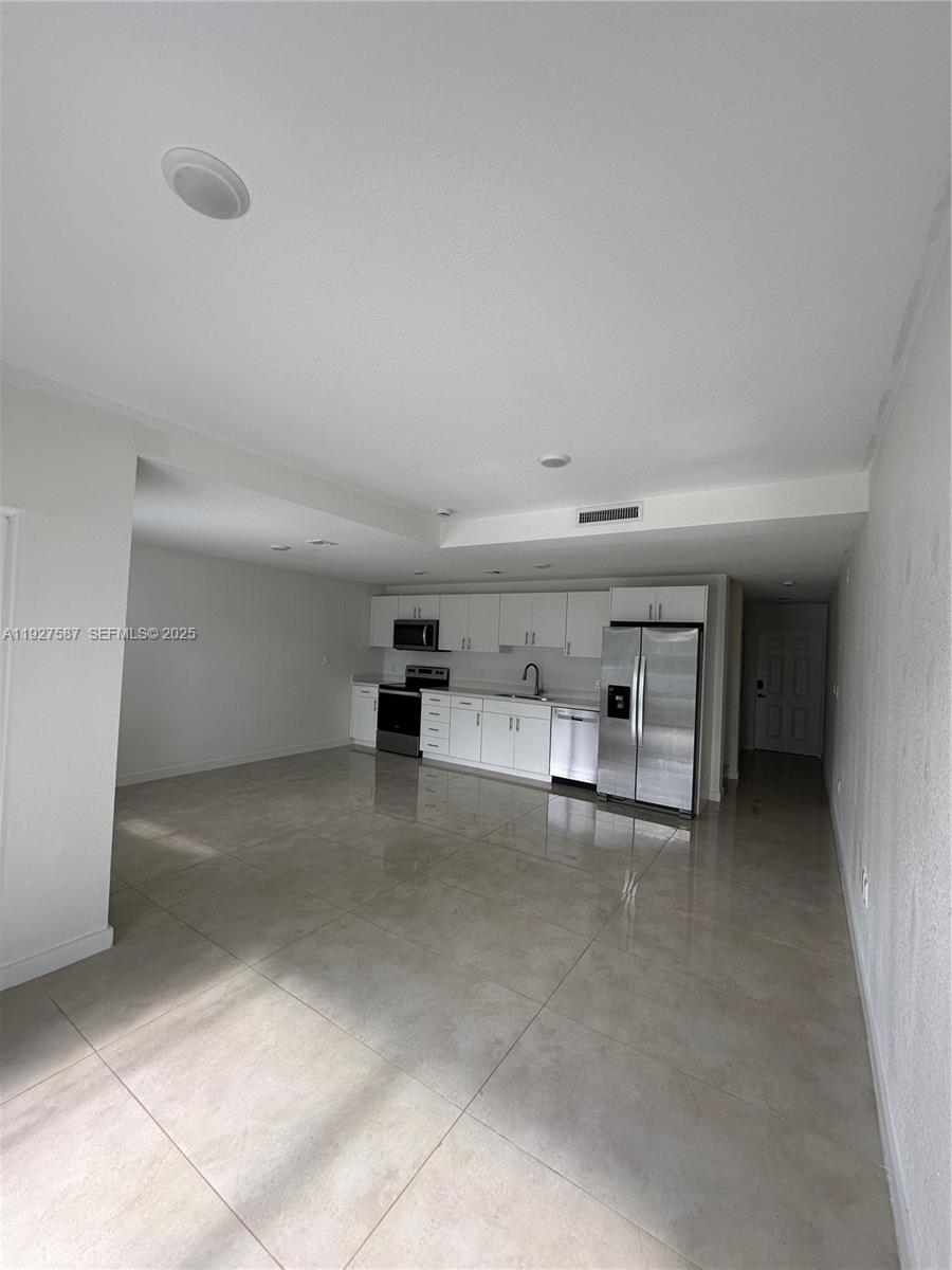 14573 Southwest 261st Terrace, Unit 14573 Homestead, FL 33032 - Photo 10 of 35 a view of a livingroom with a staircase