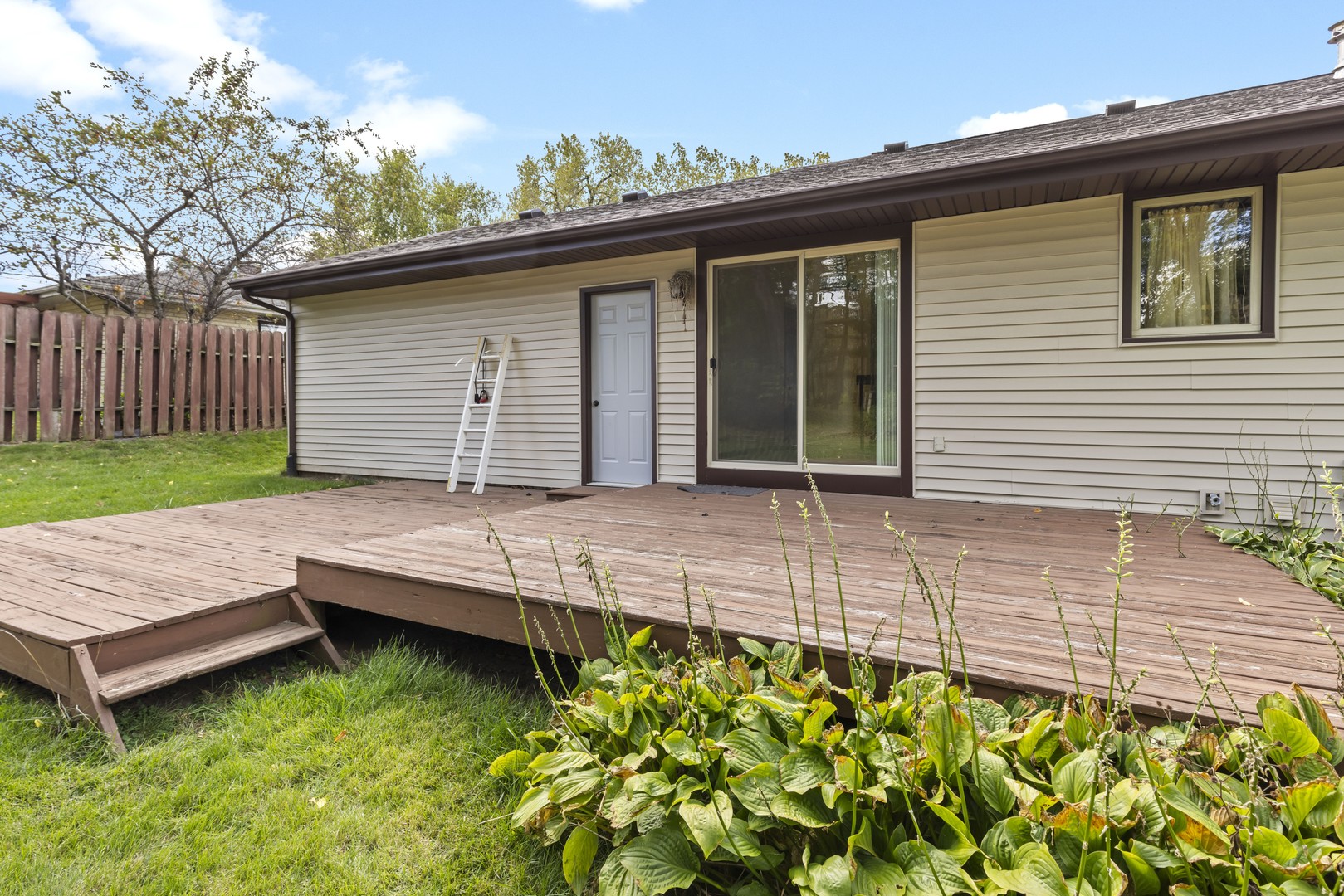 3626 Toft Street Rockford, IL 61114 - Photo 19 of 22 a view of a house with a wooden deck and a yard
