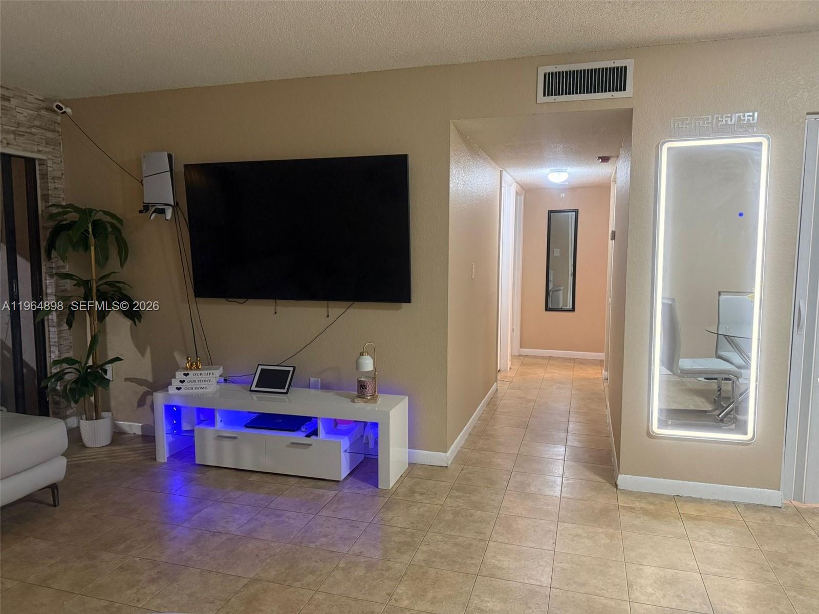 7421 Southwest 152nd Avenue, Unit 9202 Miami, FL 33193 - Photo 5 of 9 a living room with furniture and a flat screen tv