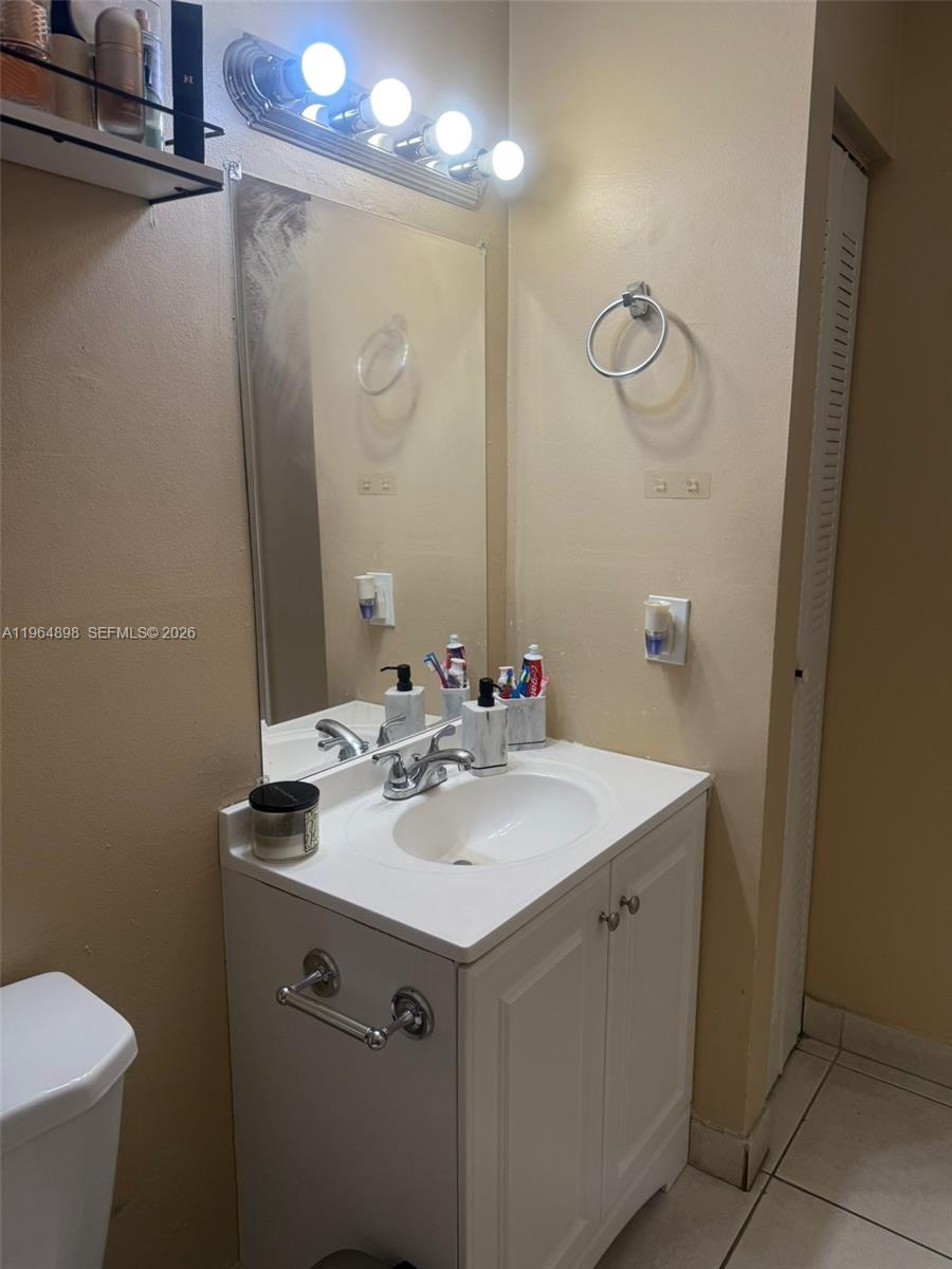 7421 Southwest 152nd Avenue, Unit 9202 Miami, FL 33193 - Photo 8 of 9 a bathroom with a sink and mirror with toilet