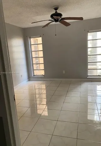 a view of an empty room and window chandelier fan