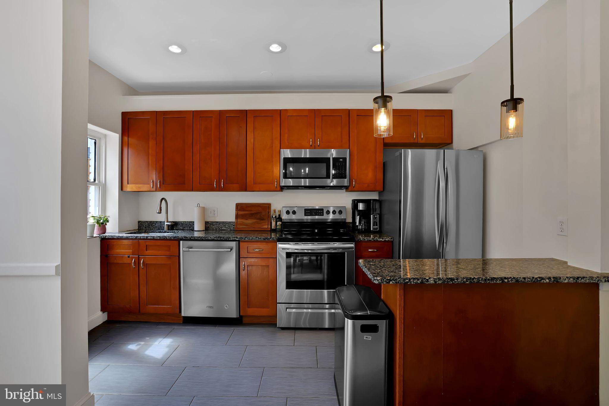 1719 Lyman Place Northeast Washington, DC 20002 - Photo 13 of 32 a kitchen with stainless steel appliances granite countertop a stove a sink and a refrigerator