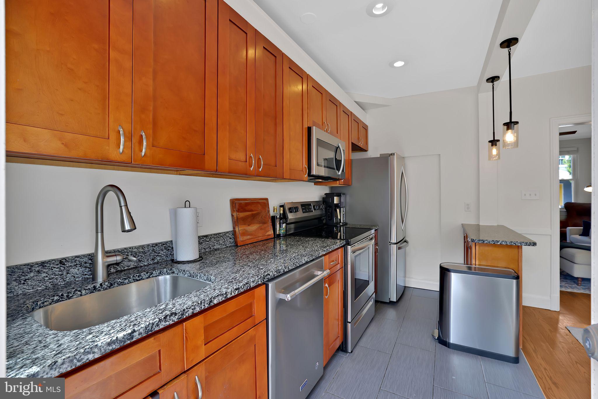 1719 Lyman Place Northeast Washington, DC 20002 - Photo 14 of 32 a kitchen with stainless steel appliances granite countertop a sink a stove and a refrigerator