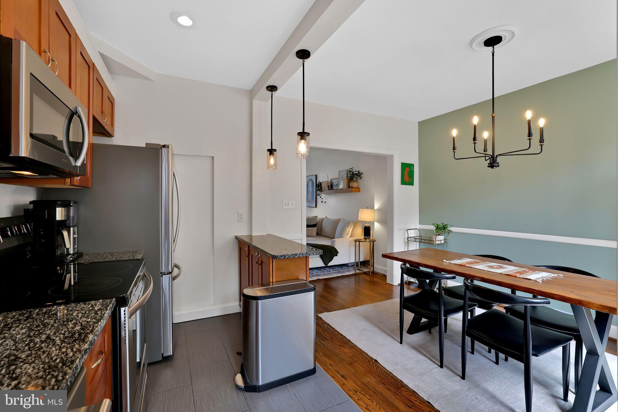 1719 Lyman Place Northeast Washington, DC 20002 - Photo 15 of 32 a kitchen with stainless steel appliances kitchen island granite countertop a table chairs and a refrigerator