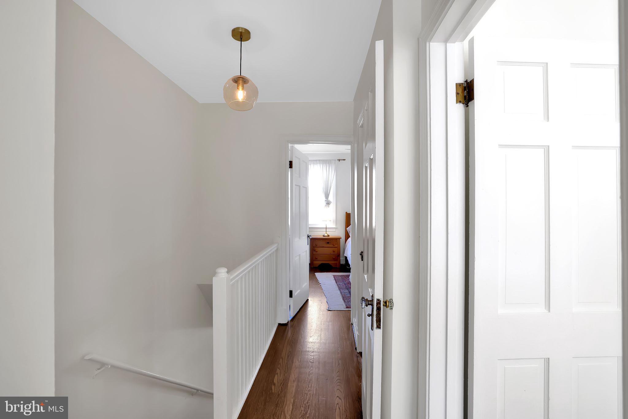 1719 Lyman Place Northeast Washington, DC 20002 - Photo 17 of 32 a view of a hallway with a chandelier and wooden floor
