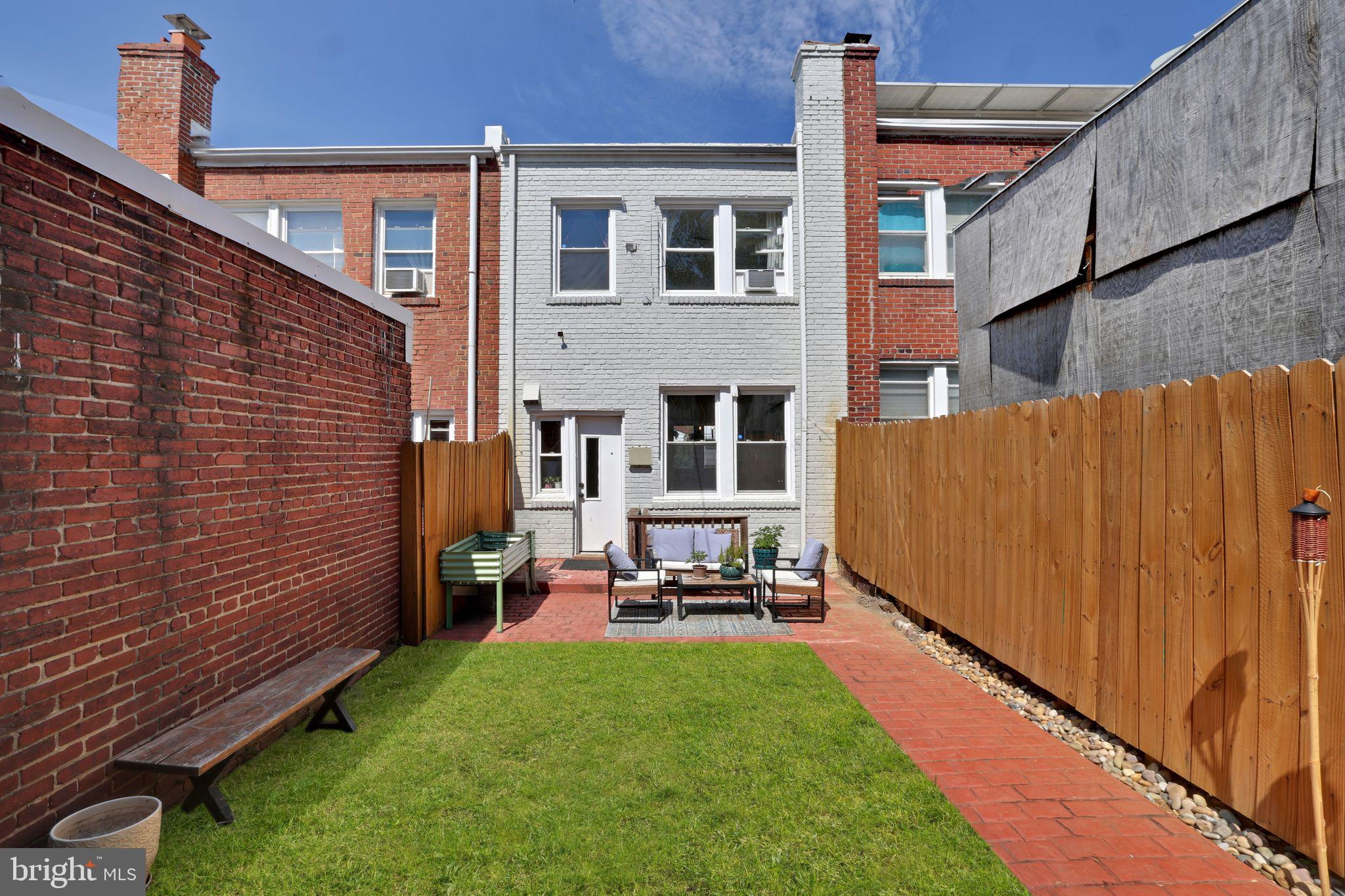 1719 Lyman Place Northeast Washington, DC 20002 - Photo 2 of 32 a backyard of a house with table and chairs