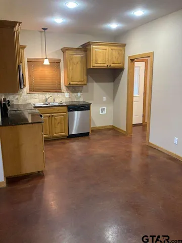 a kitchen with stainless steel appliances kitchen island granite countertop a stove a sink and a refrigerator