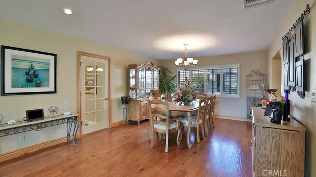 a view of a dining room and livingroom with furniture wooden floor a chandelier