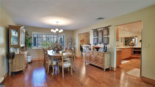a kitchen with stainless steel appliances granite countertop a table and chairs in it