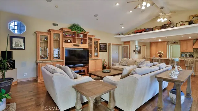 a living room with stainless steel appliances kitchen island granite countertop furniture and a flat screen tv