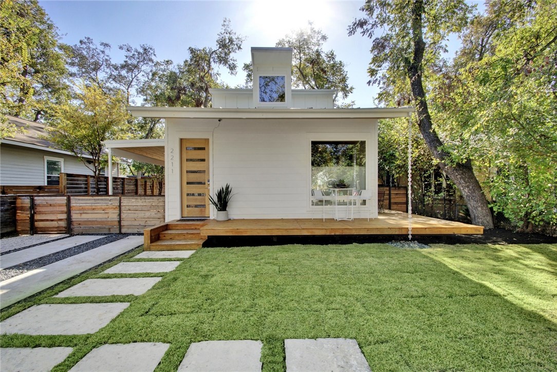 a view of a house with backyard and sitting area