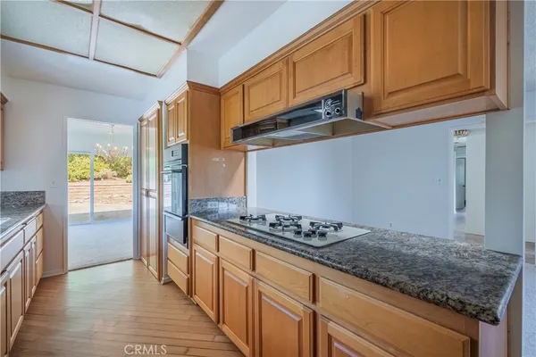 a kitchen with granite countertop wooden cabinets a sink and dishwasher