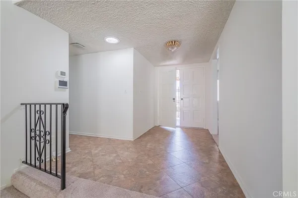 an empty room with windows and fireplace