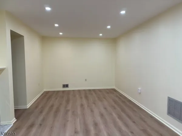 an empty room with wooden floor and white walls