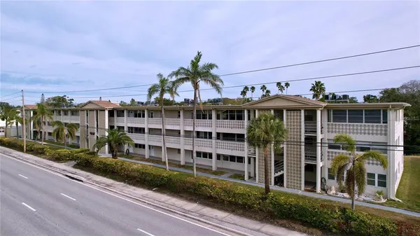 a front view of a building with a garden and balcony