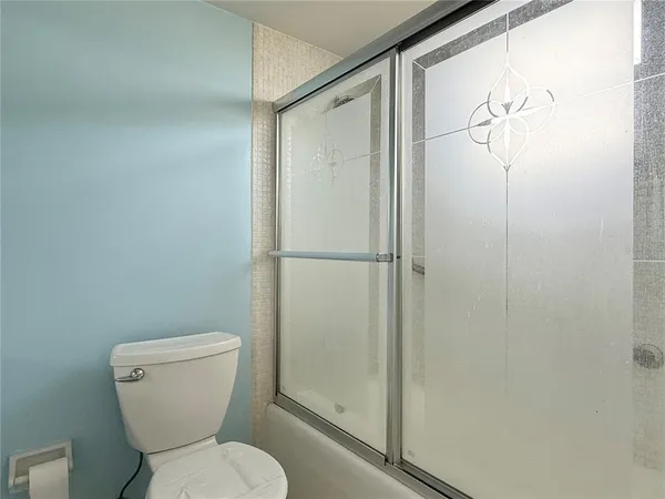 a white toilet sitting next to a shower