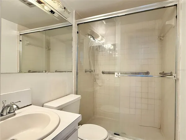 a bathroom with a sink shower and a mirror