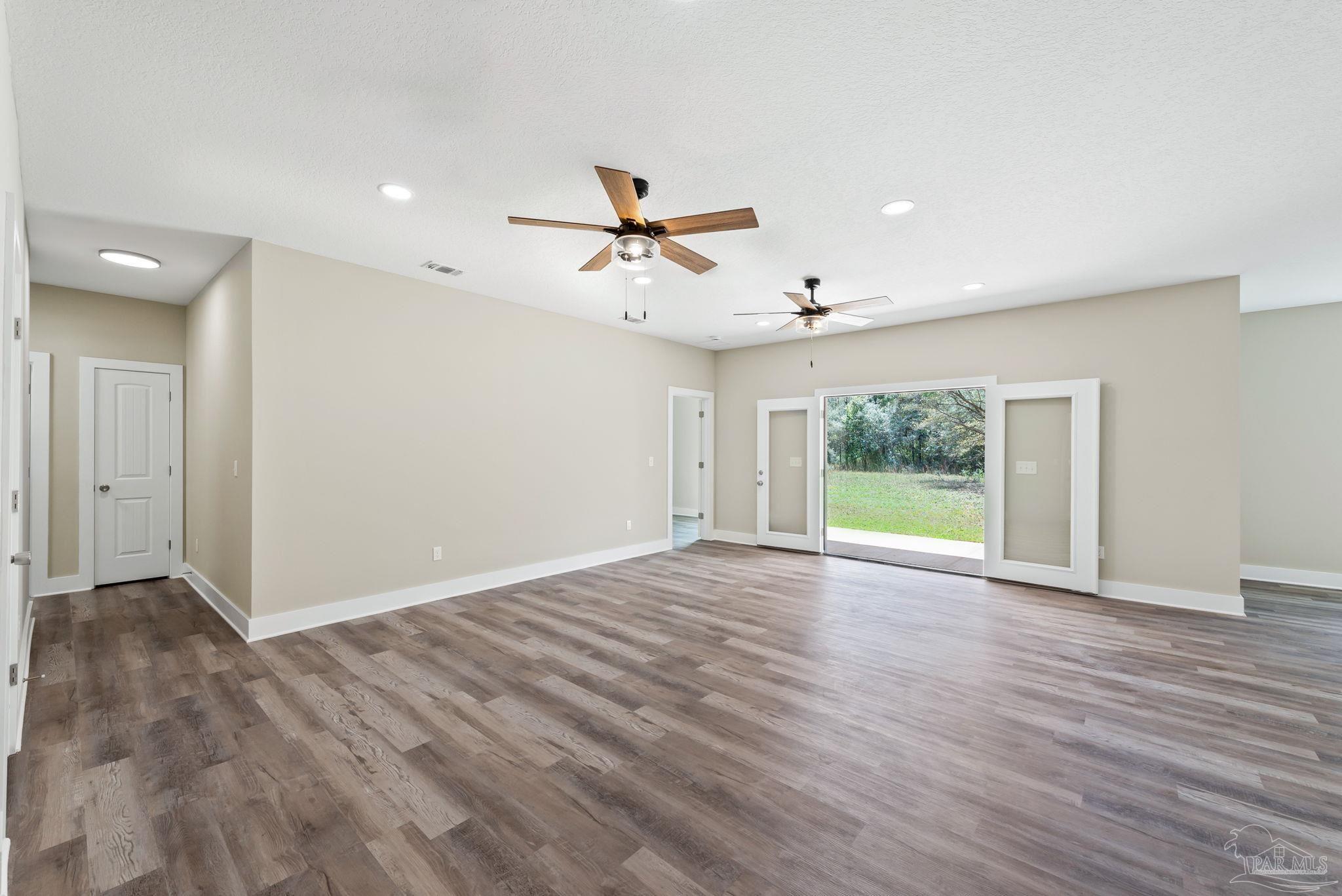 8261 Larson Lane Milton, FL 32583 - Photo 16 of 47 a view of an empty room with a window and wooden floor