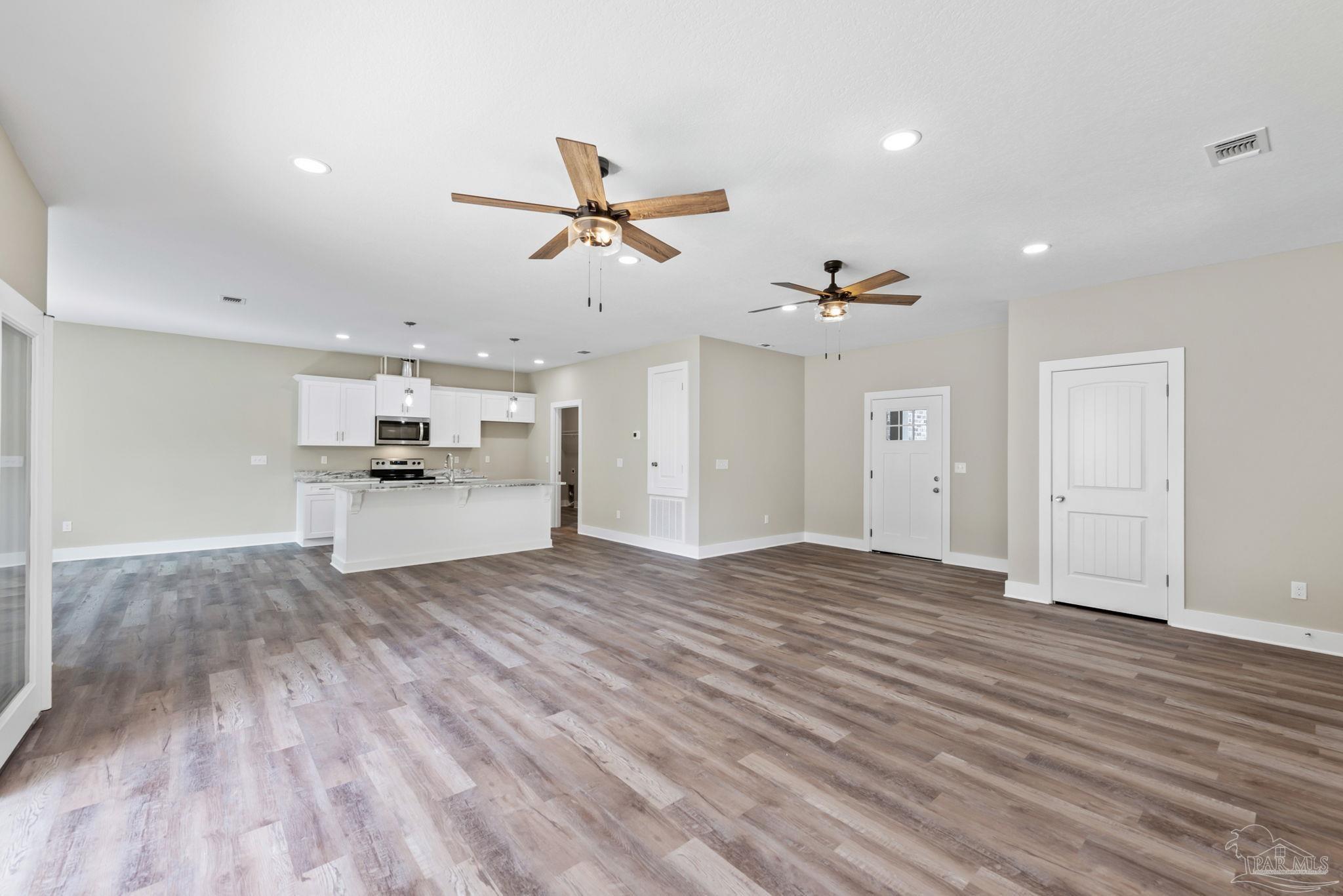 8261 Larson Lane Milton, FL 32583 - Photo 17 of 47 a view of empty room with wooden floor and ceiling fan