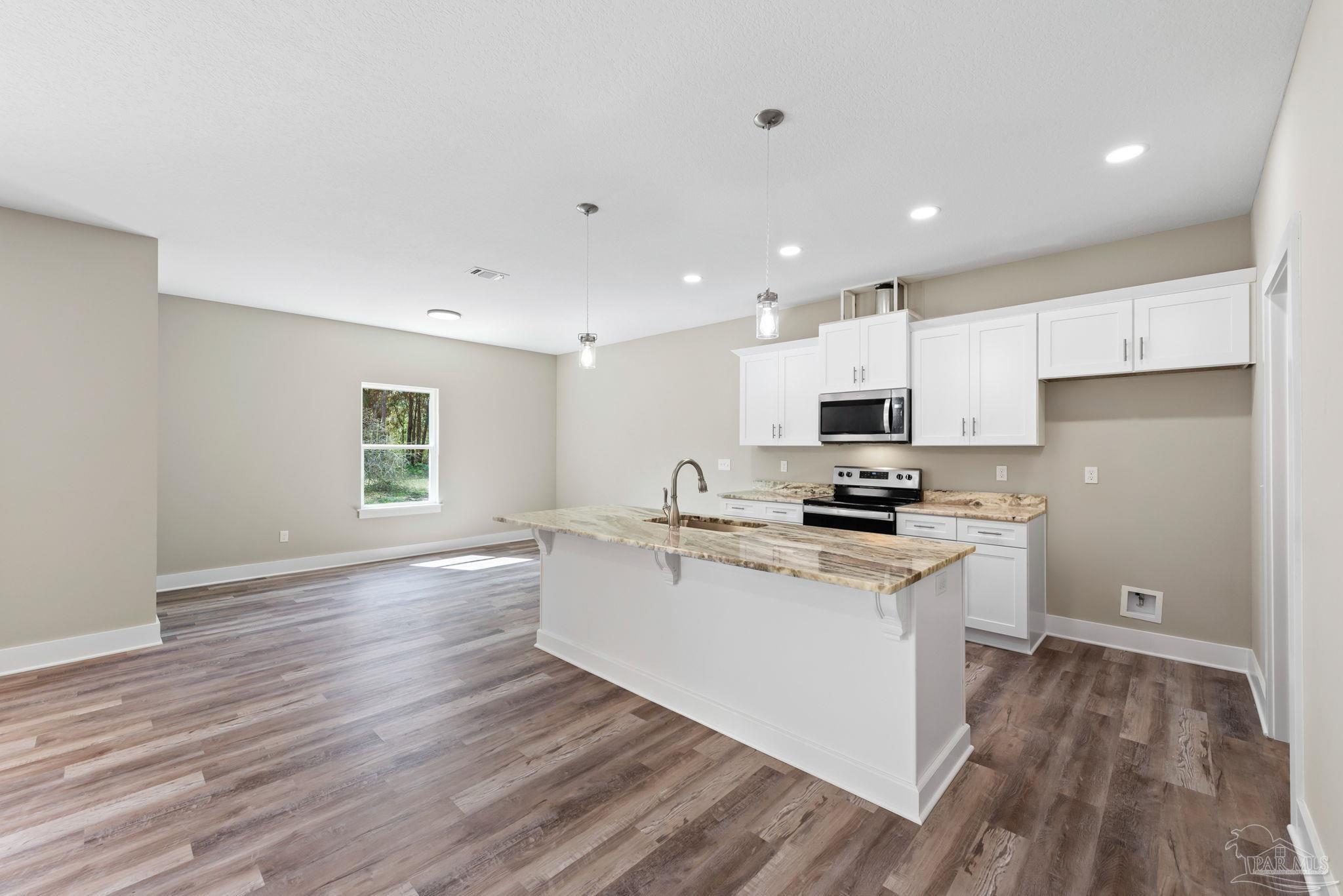 8261 Larson Lane Milton, FL 32583 - Photo 19 of 47 a kitchen with stainless steel appliances granite countertop a stove a sink and a refrigerator