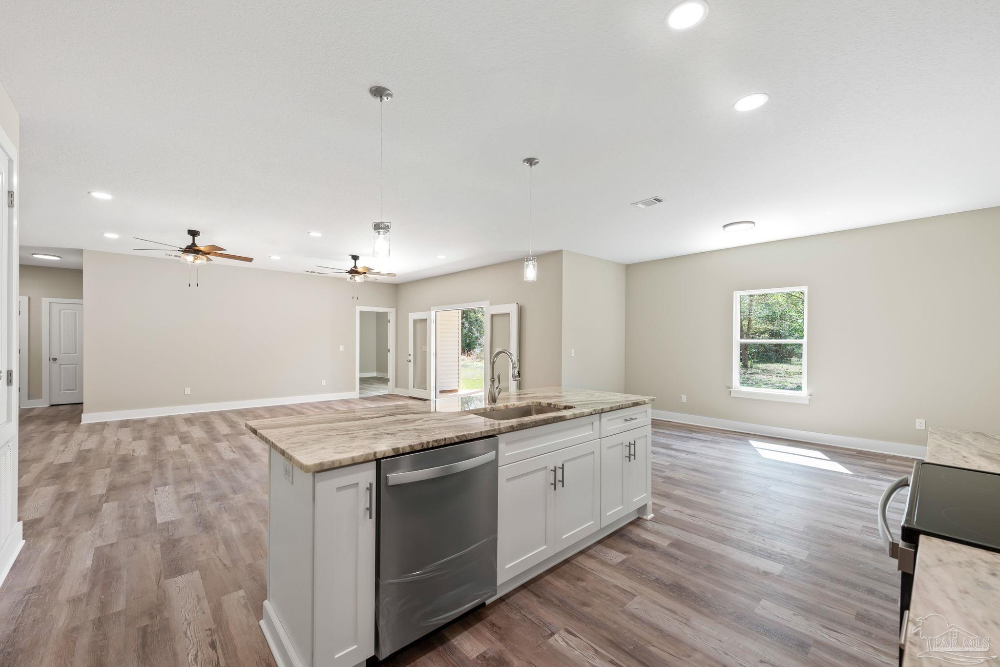 8261 Larson Lane Milton, FL 32583 - Photo 23 of 47 a kitchen with a sink stove and wooden floor