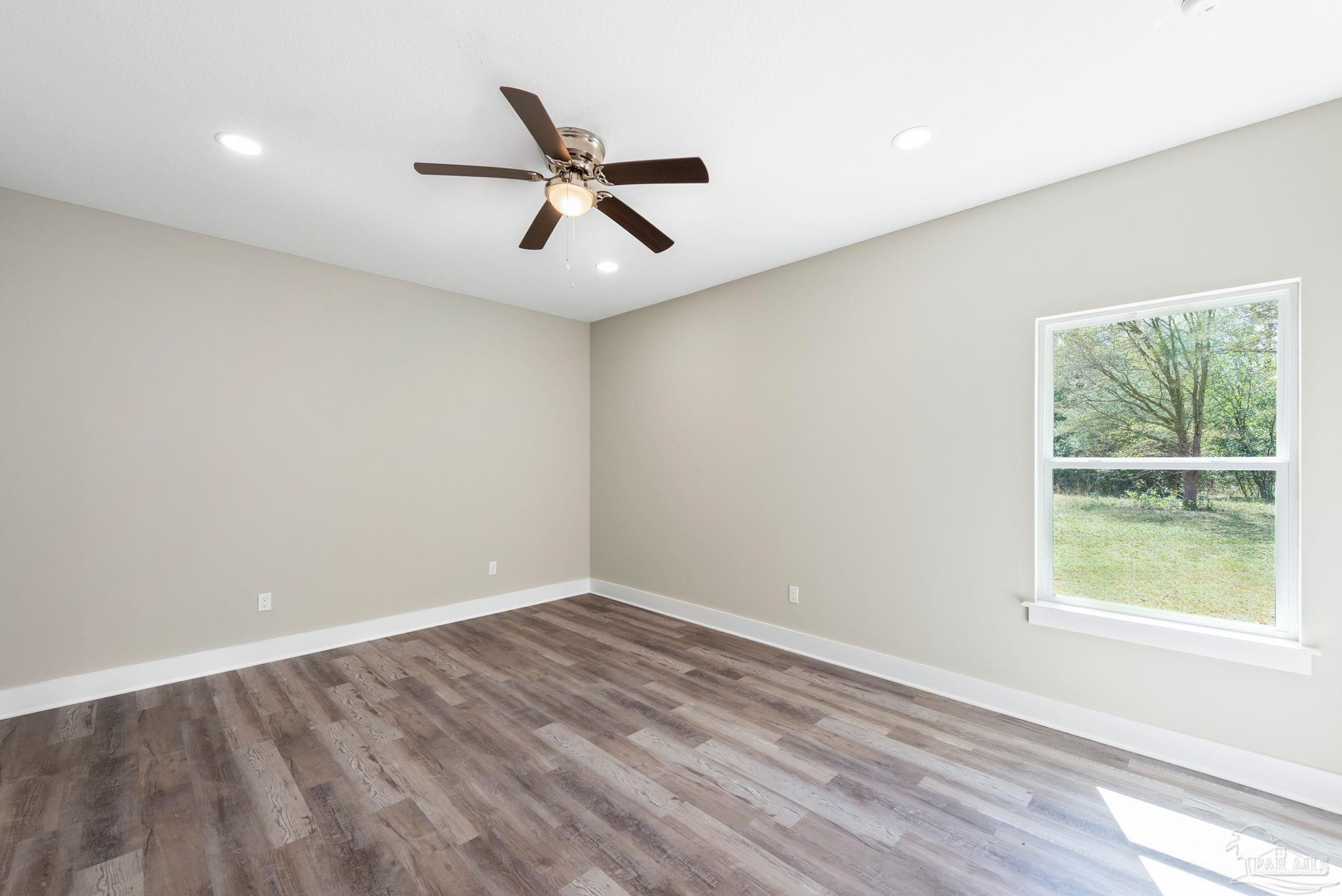 8261 Larson Lane Milton, FL 32583 - Photo 28 of 47 wooden floor in an empty room with a window