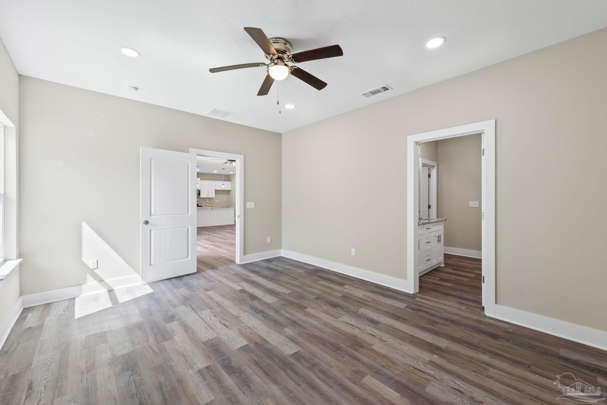 8261 Larson Lane Milton, FL 32583 - Photo 29 of 47 an empty room with wooden floor and a ceiling fan