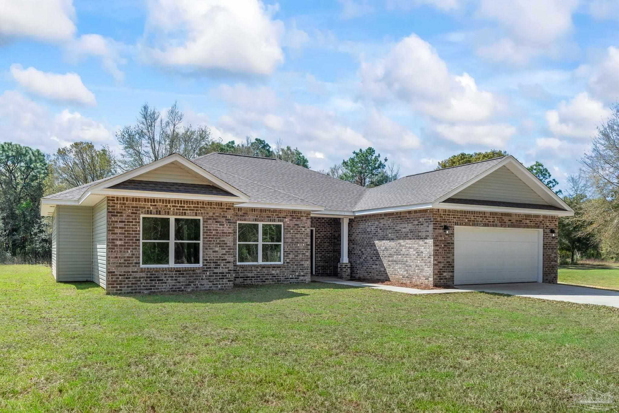 8261 Larson Lane Milton, FL 32583 - Photo 3 of 47 front view of a house with a garden