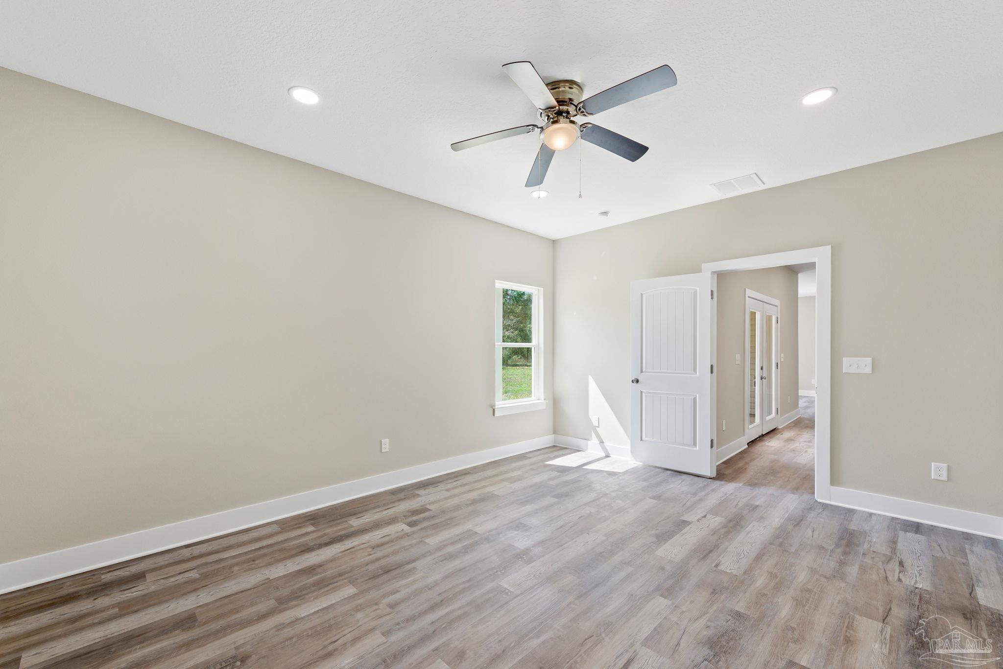8261 Larson Lane Milton, FL 32583 - Photo 32 of 47 wooden floor in an empty room with a window