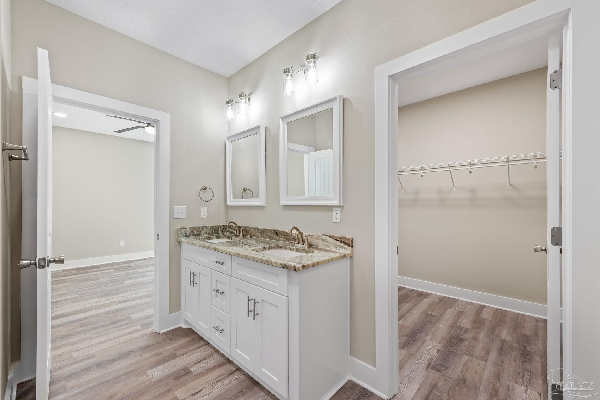 8261 Larson Lane Milton, FL 32583 - Photo 34 of 47 a bathroom with a granite countertop sink a mirror and a shower