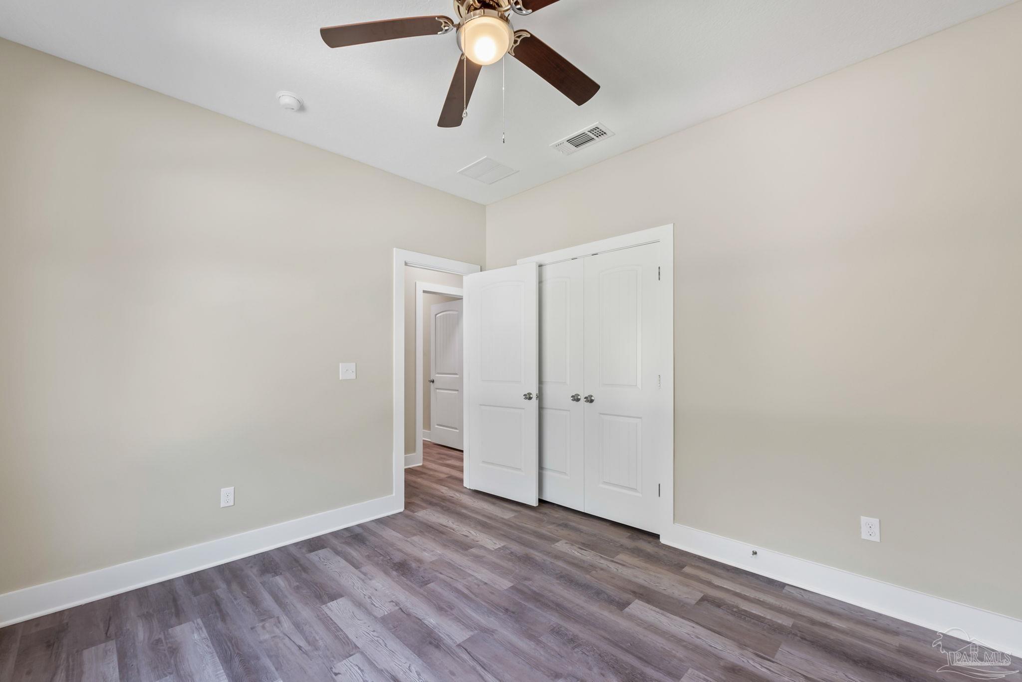 8261 Larson Lane Milton, FL 32583 - Photo 39 of 47 a view of an empty room with wooden floor