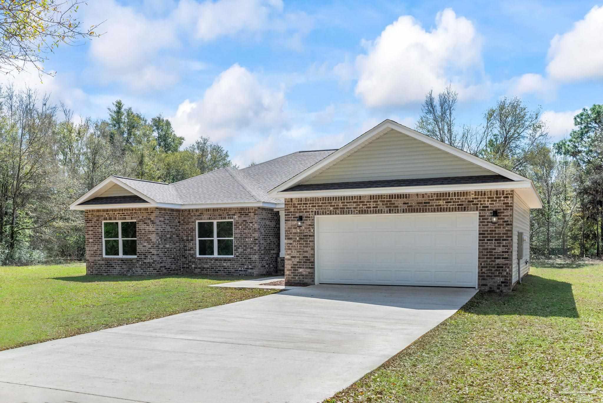 8261 Larson Lane Milton, FL 32583 - Photo 4 of 47 a front view of a house with a garden and yard