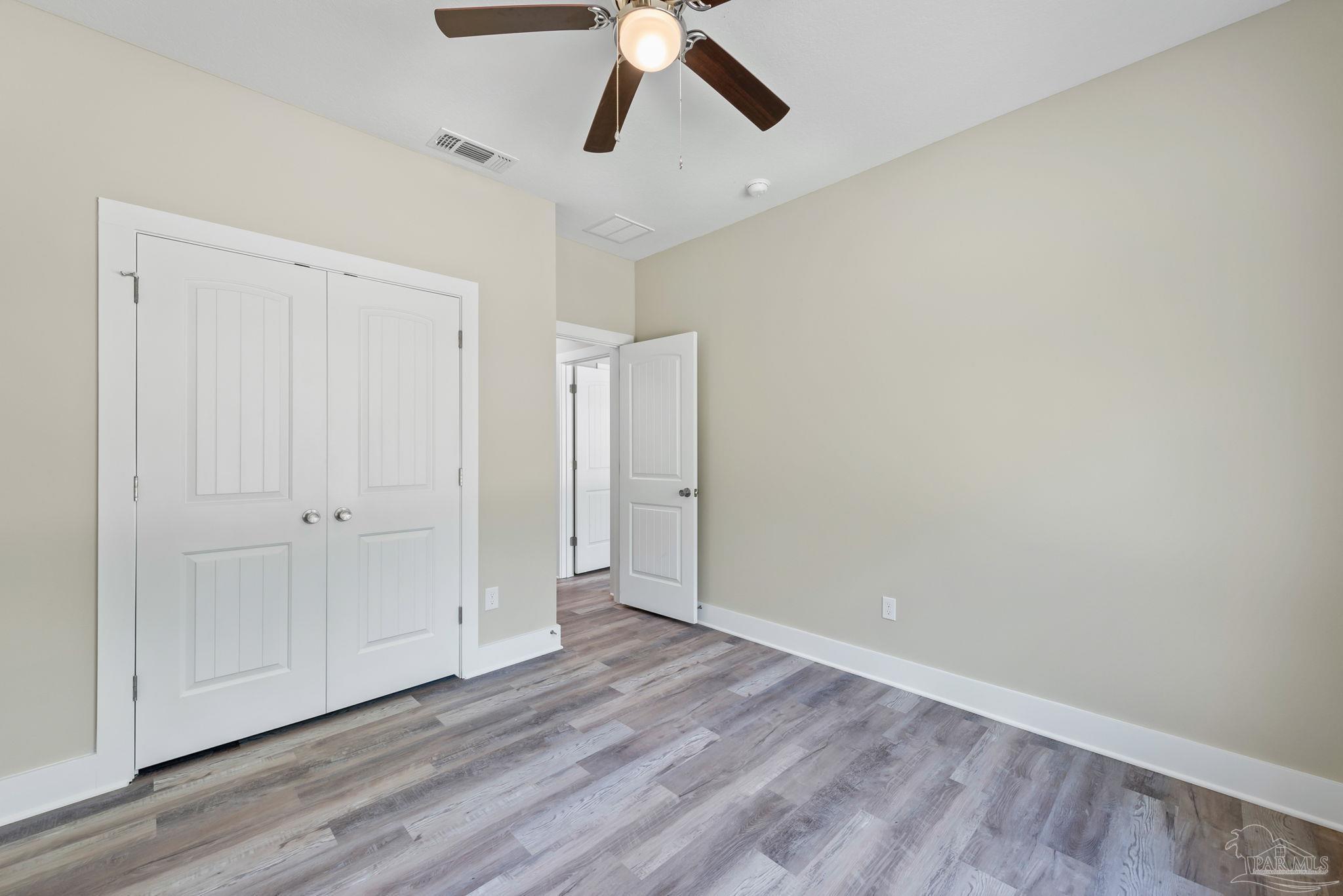 8261 Larson Lane Milton, FL 32583 - Photo 41 of 47 a view of empty room with wooden floor