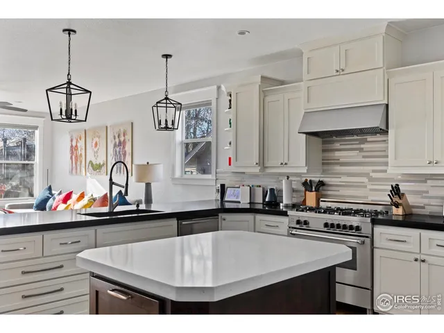 a kitchen with stainless steel appliances kitchen island granite countertop a sink stove and refrigerator