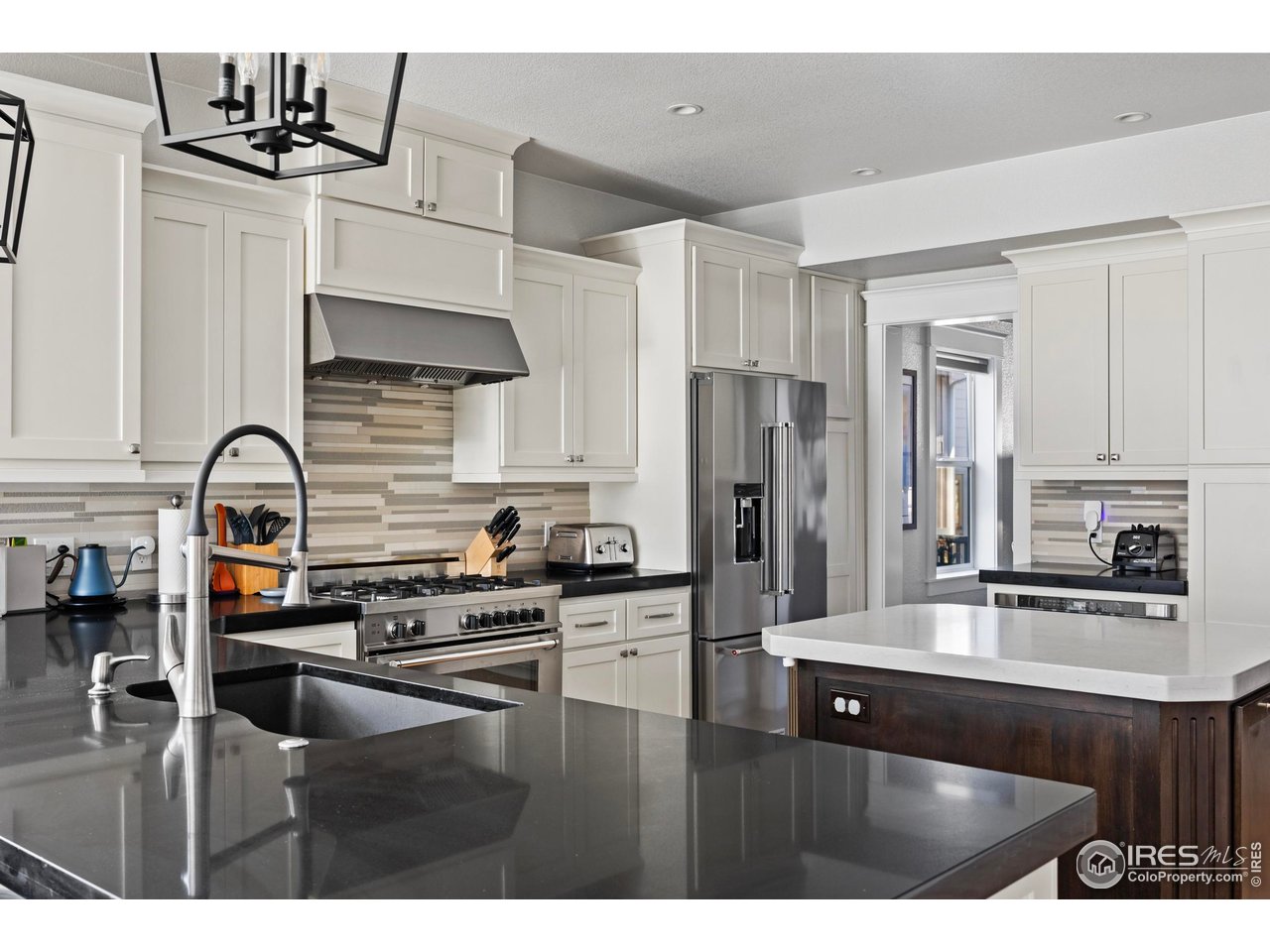 1201 Juniper Court Fort Collins, CO 80521 - Photo 14 of 50 a kitchen with stainless steel appliances kitchen island granite countertop a sink stove and refrigerator