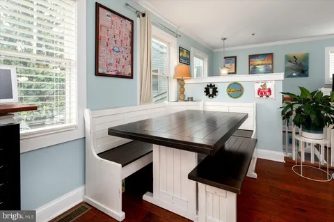 a open kitchen with stainless steel appliances granite countertop a stove a refrigerator a kitchen island a sink dishwasher a dining table and chairs with wooden floor
