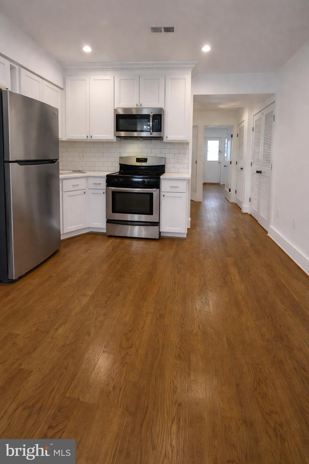 a kitchen with stainless steel appliances a refrigerator and a stove top oven