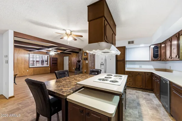 a view of an empty room with wooden floor fireplace and a window