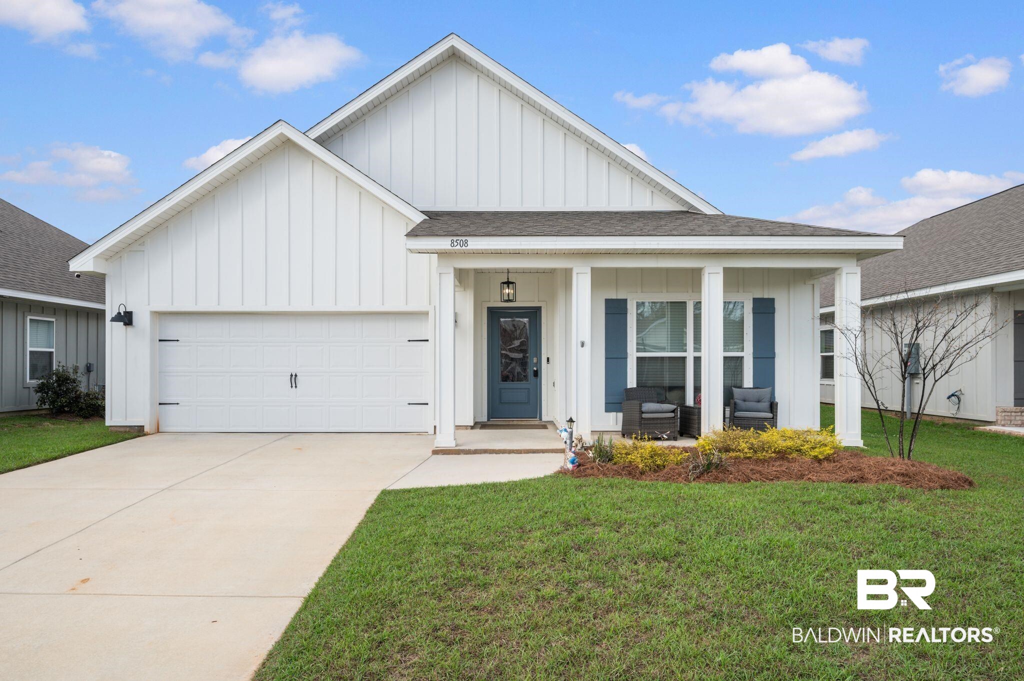8508 Rosedown Lane Daphne, AL 36526 - Photo 3 of 29 Modern farmhouse featuring board and batten siding, roof with shingles, a porch, an attached garage, and a front lawn