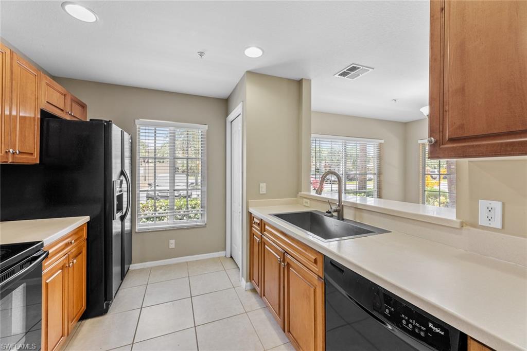 9450 Ivy Brook Run, Unit 602 Fort Myers, FL 33913 - Photo 11 of 34 a kitchen with stainless steel appliances granite countertop a sink and a refrigerator