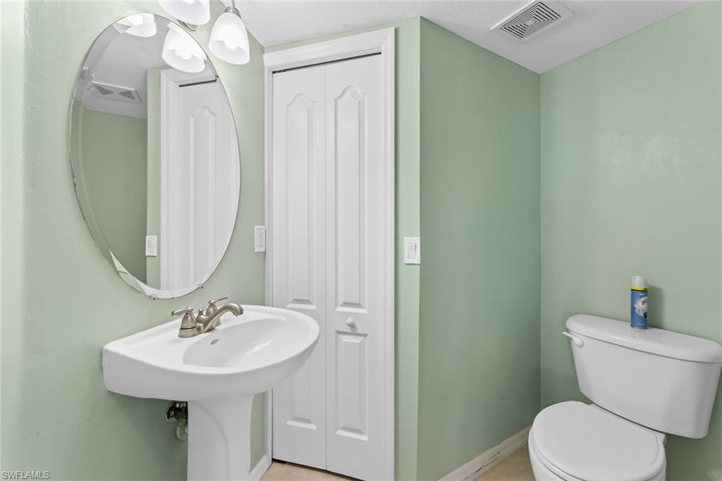 9450 Ivy Brook Run, Unit 602 Fort Myers, FL 33913 - Photo 13 of 34 a bathroom with a toilet sink and mirror