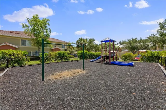 a sign board with flower plants and wooden fence