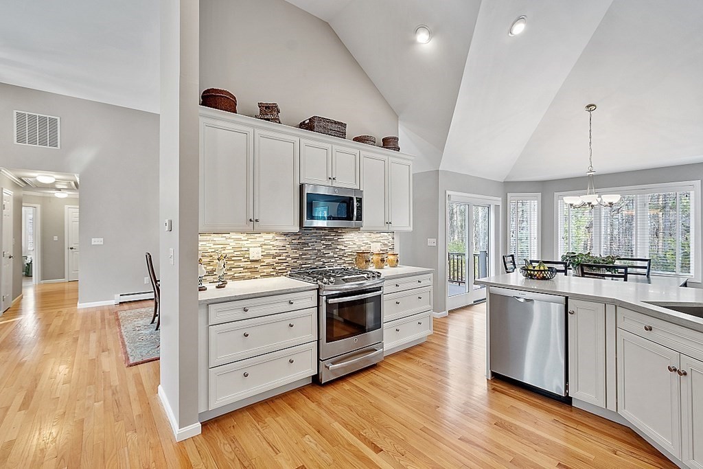 9 Joco Drive Tyngsborough, MA 01879 - Photo 11 of 38 a kitchen with stainless steel appliances kitchen island granite countertop a stove and a wooden floors